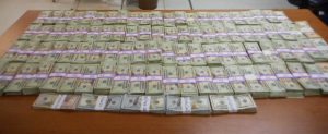 Over $200,000 in cash laid out on a wooden table seized by CBP officers in Eagle Pass Texas